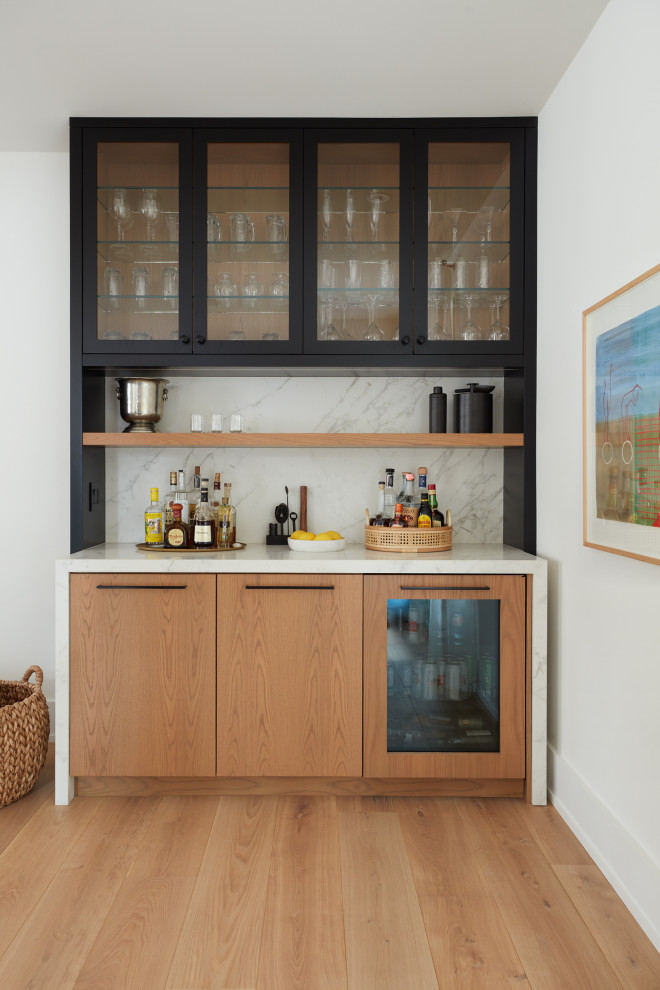 トロントにある小さなコンテンポラリースタイルのおしゃれなドライ バー (I型、フラットパネル扉のキャビネット、淡色木目調キャビネット、白いキッチンパネル、淡色無垢フローリング、白いキッチンカウンター) の写真