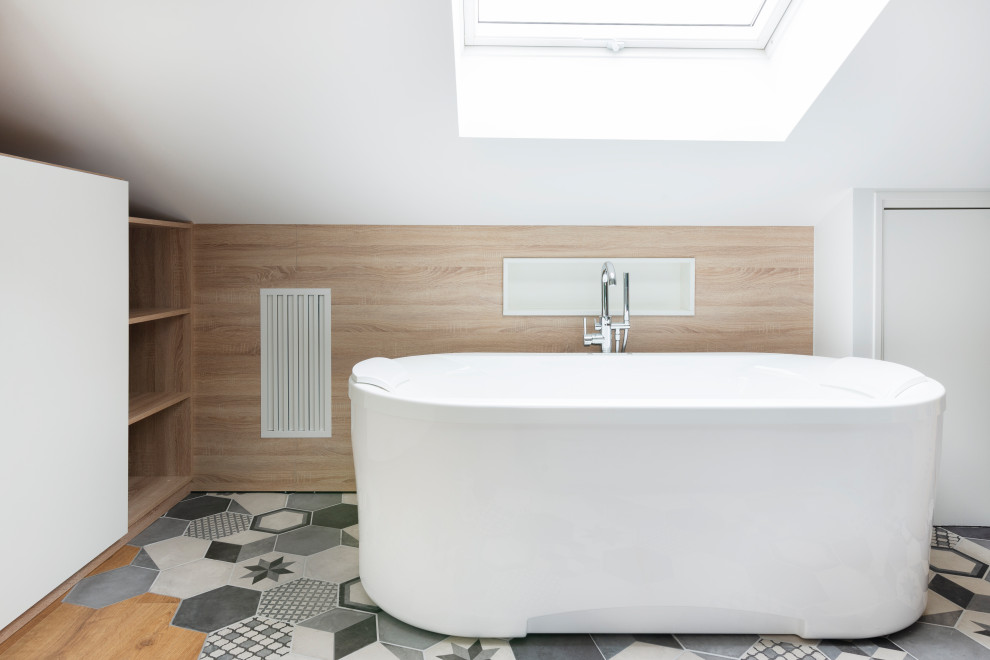 На фото: большая ванная комната в белых тонах с отделкой деревом в современном стиле с белыми стенами, полом из ламината, коричневым полом, плоскими фасадами, белыми фасадами, отдельно стоящей ванной, душем над ванной, открытым душем и деревянными стенами