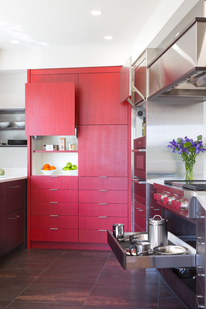 This is an example of a mid-sized contemporary u-shaped kitchen in Seattle with an undermount sink, flat-panel cabinets, red cabinets, quartz benchtops, white splashback, stone slab splashback, stainless steel appliances, porcelain floors and a peninsula.