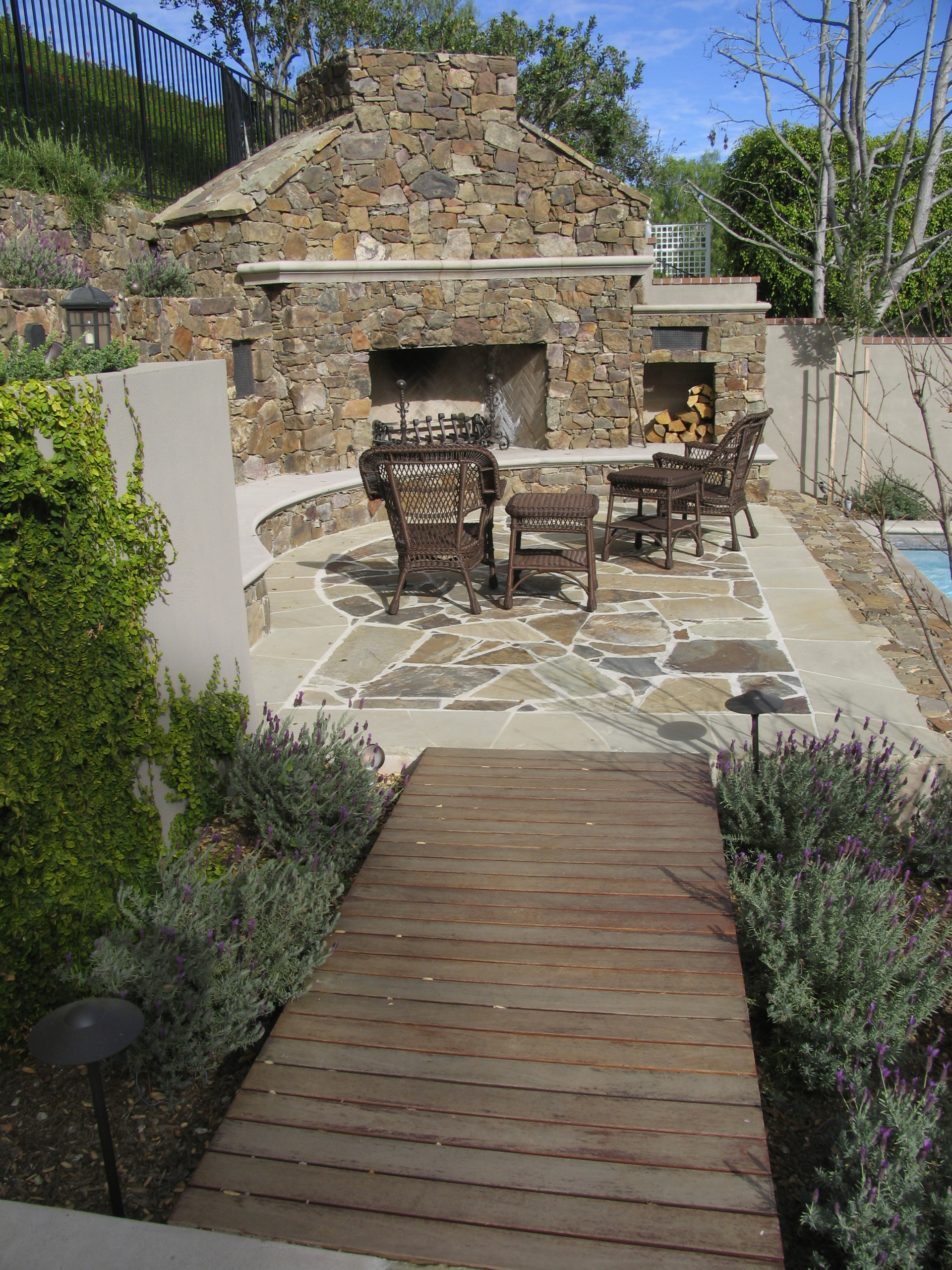 Stone fireplace with seat wall and patio and ipe walkway