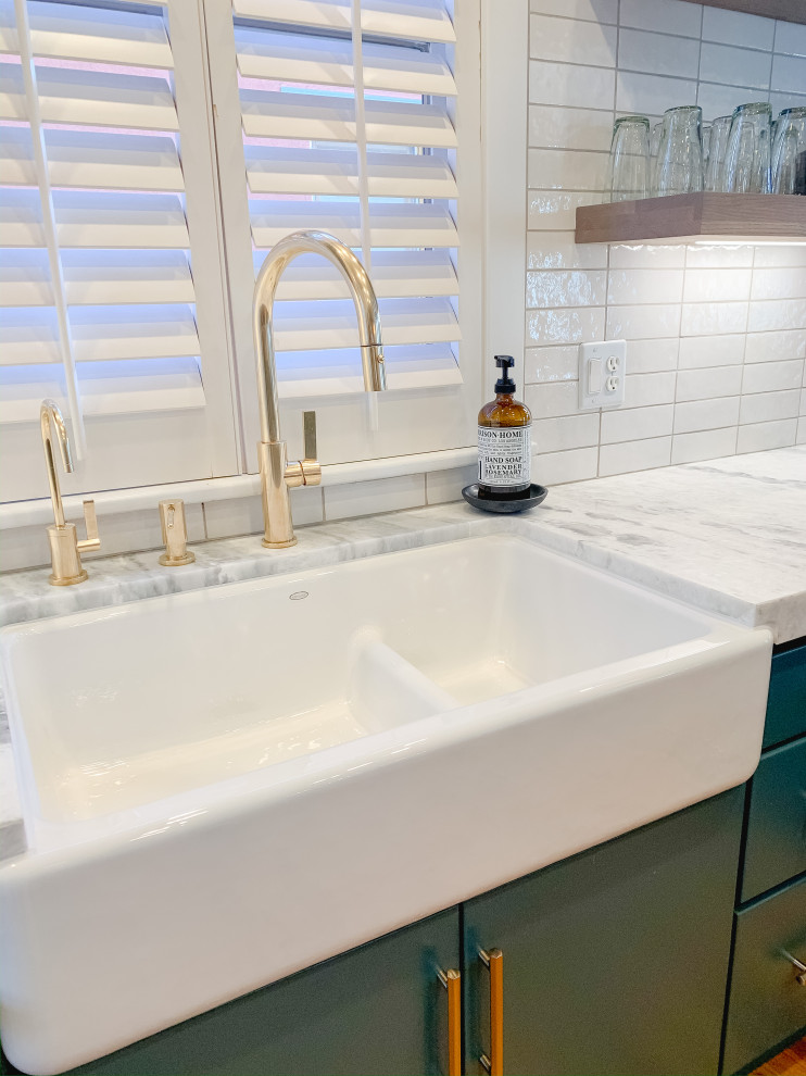 Open concept kitchen - mid-sized transitional u-shaped medium tone wood floor open concept kitchen idea in Denver with a farmhouse sink, flat-panel cabinets, turquoise cabinets, quartzite countertops, white backsplash, ceramic backsplash, stainless steel appliances and white countertops