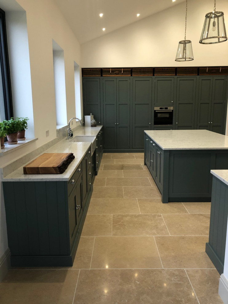 Photo of an expansive traditional kitchen in Surrey with beaded cabinets, green cabinets, an island and white worktops.