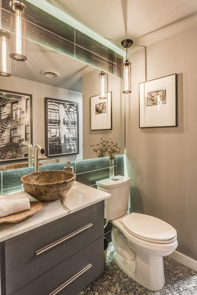 Industrial powder room in Atlanta with flat-panel cabinets, grey cabinets, a two-piece toilet, mosaic tile floors, a vessel sink, beige walls and multi-coloured floor.