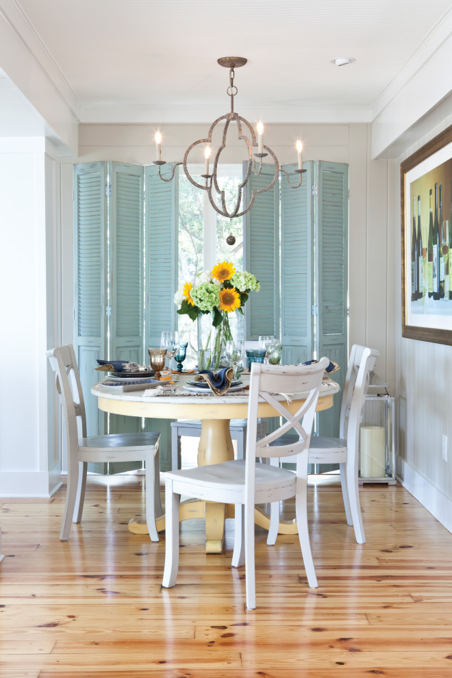 Photo of a beach style dining room in Other with grey walls, light hardwood floors, beige floor and planked wall panelling.