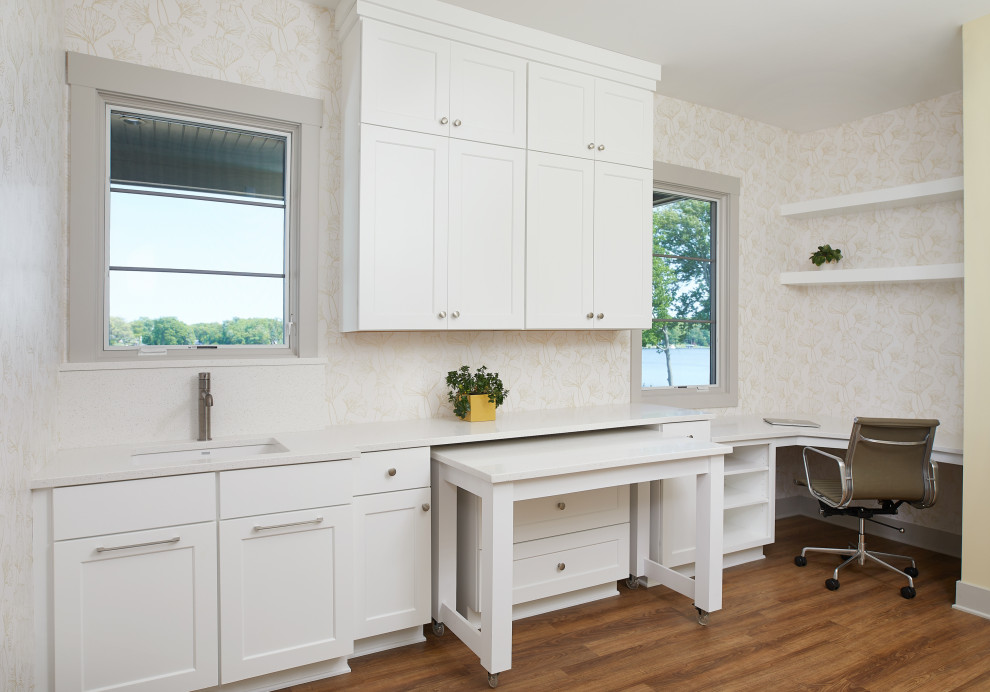 Design ideas for a mid-sized modern l-shaped utility room in Grand Rapids with an undermount sink, recessed-panel cabinets, white cabinets, quartzite benchtops, white walls, medium hardwood floors, brown floor and white benchtop.