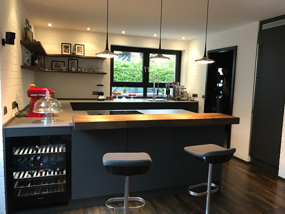 Design ideas for a large industrial u-shaped eat-in kitchen in Other with an integrated sink, flat-panel cabinets, grey cabinets, quartz benchtops, white splashback, brick splashback, stainless steel appliances, dark hardwood floors, a peninsula and yellow benchtop.