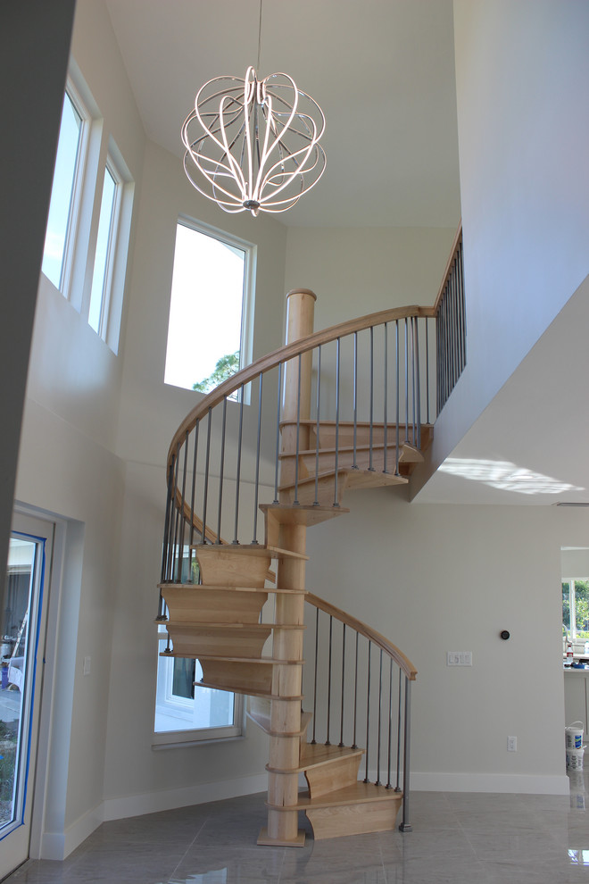 Photo of a small transitional wood spiral staircase in Other with wood risers and mixed railing.