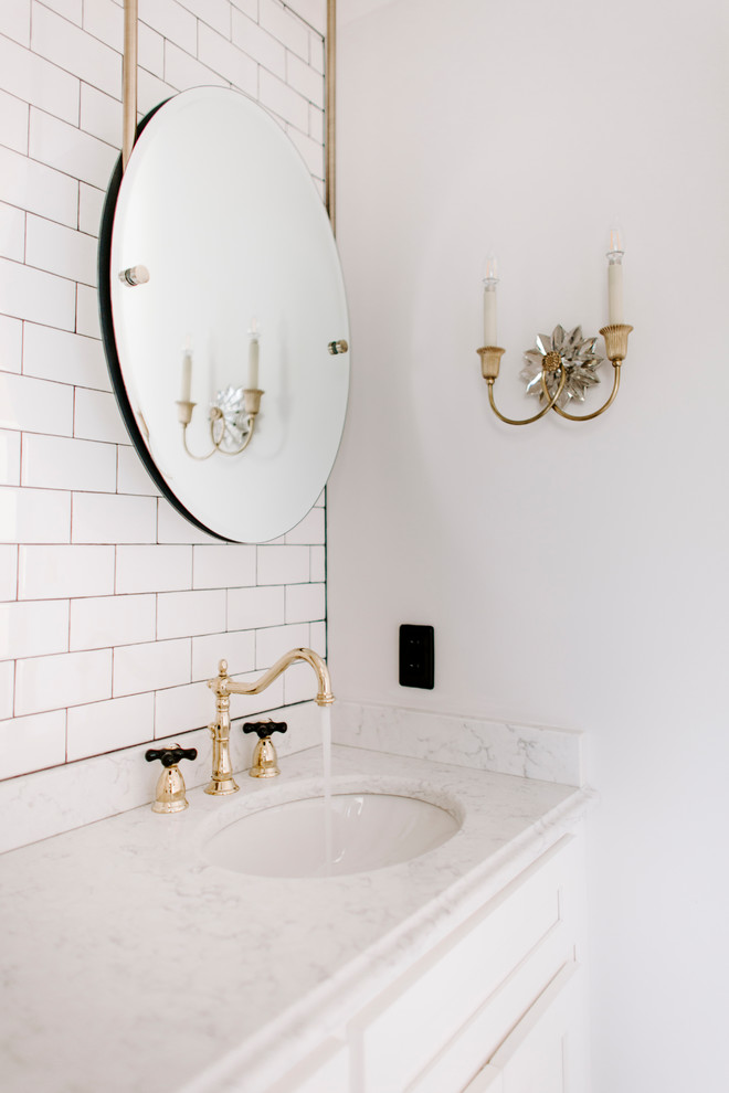 This is an example of a mid-sized modern kids bathroom in Nashville with shaker cabinets, white cabinets, an alcove shower, a one-piece toilet, white tile, ceramic tile, grey walls, marble floors, an undermount sink, quartzite benchtops, black floor, a hinged shower door and white benchtops.