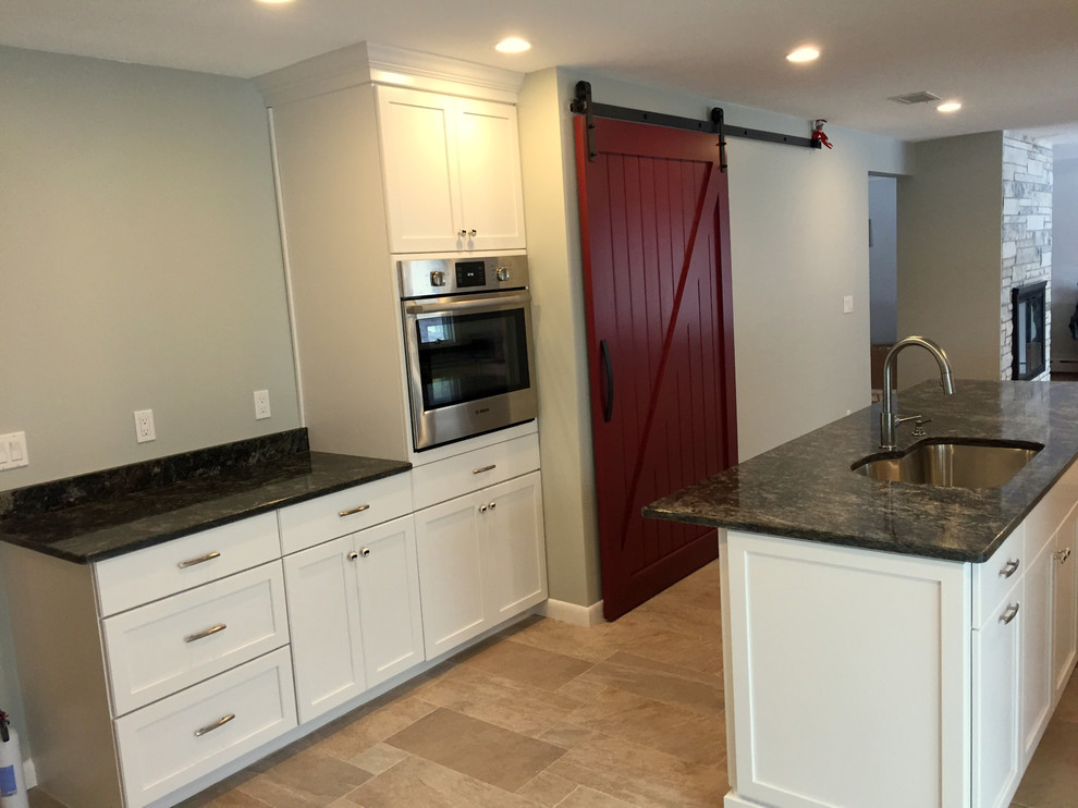 Mid-sized transitional l-shaped kitchen photo in Boston with shaker cabinets, white cabinets, marble countertops and an island