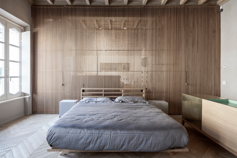 Inspiration for a contemporary bedroom in Milan with light hardwood floors.