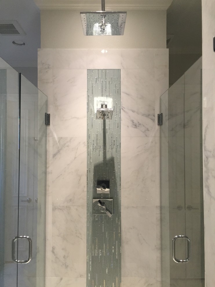 This is an example of a large modern master bathroom in Dallas with raised-panel cabinets, white cabinets, a freestanding tub, an alcove shower, a one-piece toilet, white tile, stone tile, grey walls and marble floors.