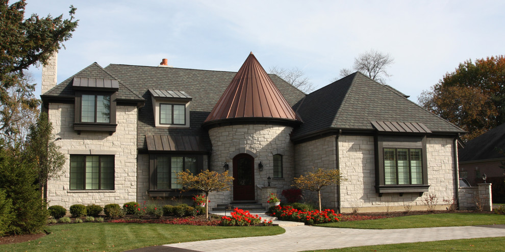 Design ideas for a large traditional two-storey grey exterior in Chicago with stone veneer and a hip roof.