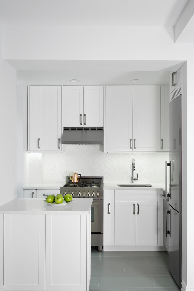 Photo of a small transitional l-shaped kitchen in New York with an undermount sink, white cabinets, quartz benchtops, white splashback, subway tile splashback, stainless steel appliances, porcelain floors, shaker cabinets and a peninsula.