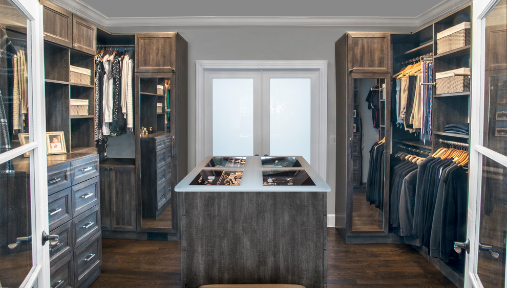 This is an example of a mid-sized transitional gender-neutral walk-in wardrobe in Chicago with recessed-panel cabinets, distressed cabinets, dark hardwood floors and brown floor.