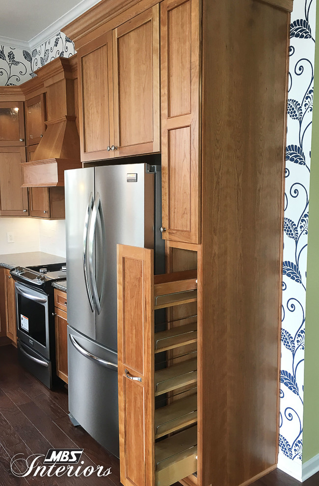Example of a mid-sized transitional l-shaped dark wood floor and brown floor eat-in kitchen design with an undermount sink, recessed-panel cabinets, medium tone wood cabinets, granite countertops, white backsplash, ceramic backsplash, stainless steel appliances and an island