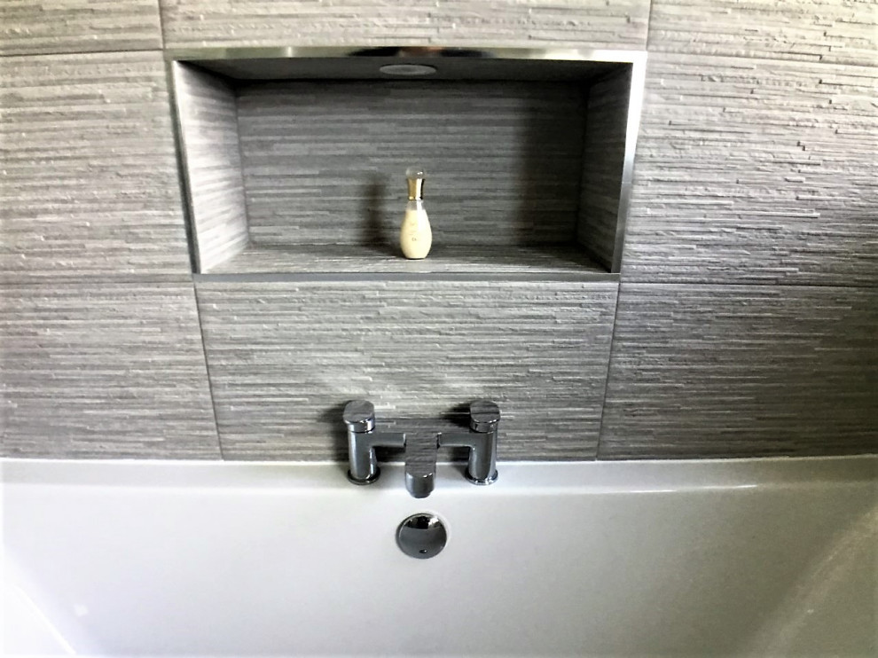 Inspiration for a medium sized modern family bathroom in Other with flat-panel cabinets, white cabinets, a built-in bath, a shower/bath combination, a two-piece toilet, grey tiles, porcelain tiles, grey walls, porcelain flooring, grey floors, a hinged door, a single sink and a freestanding vanity unit.