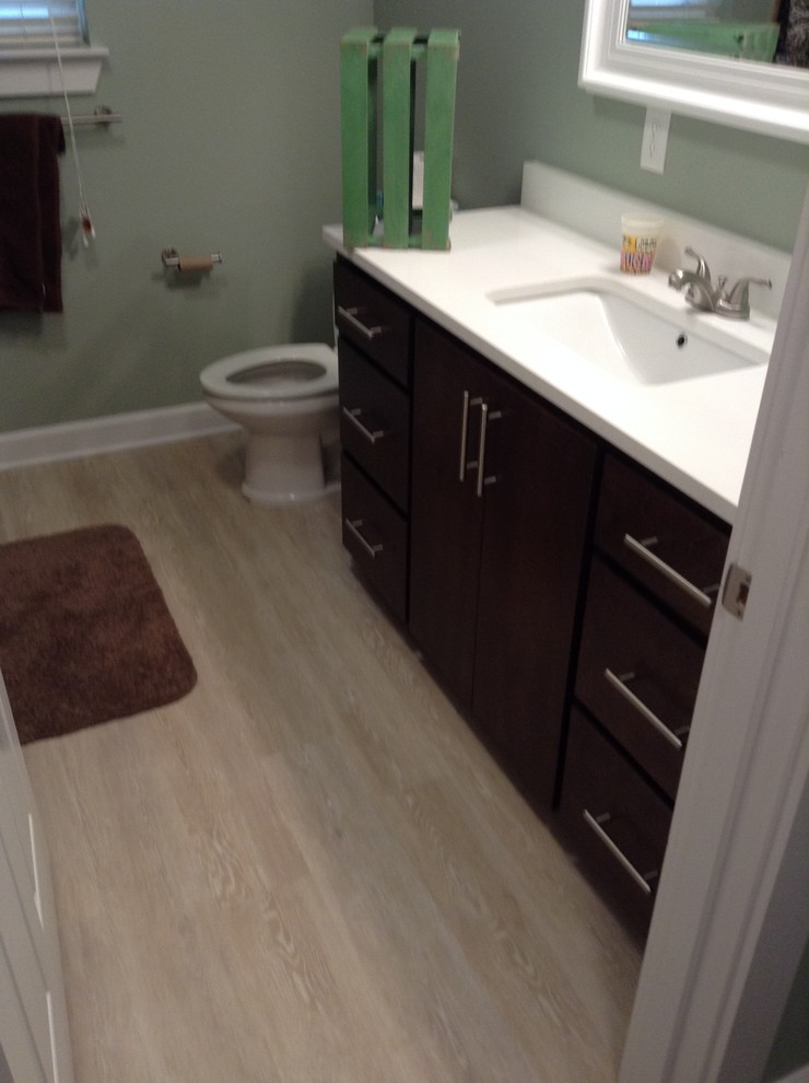 This is an example of a mid-sized contemporary kids bathroom in New Orleans with flat-panel cabinets, dark wood cabinets, an alcove tub, a shower/bathtub combo, a one-piece toilet, grey walls, vinyl floors, an undermount sink, engineered quartz benchtops, white floor and a shower curtain.