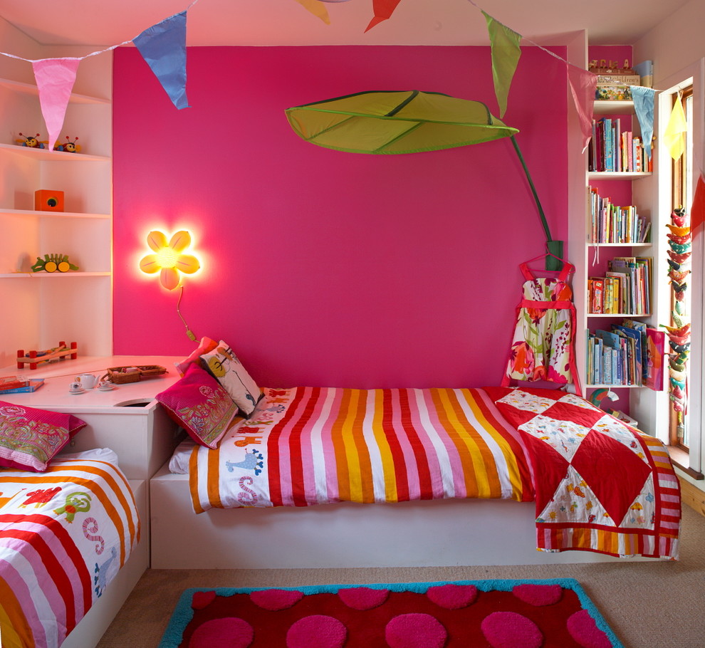 Design ideas for a mid-sized eclectic kids' bedroom for kids 4-10 years old and girls in Dublin with pink walls and carpet.