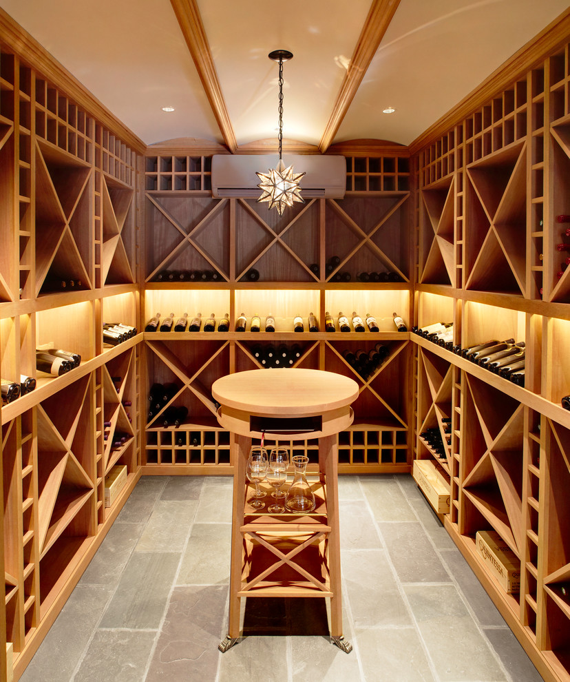 Photo of a traditional wine cellar in New York with display racks and grey floor.