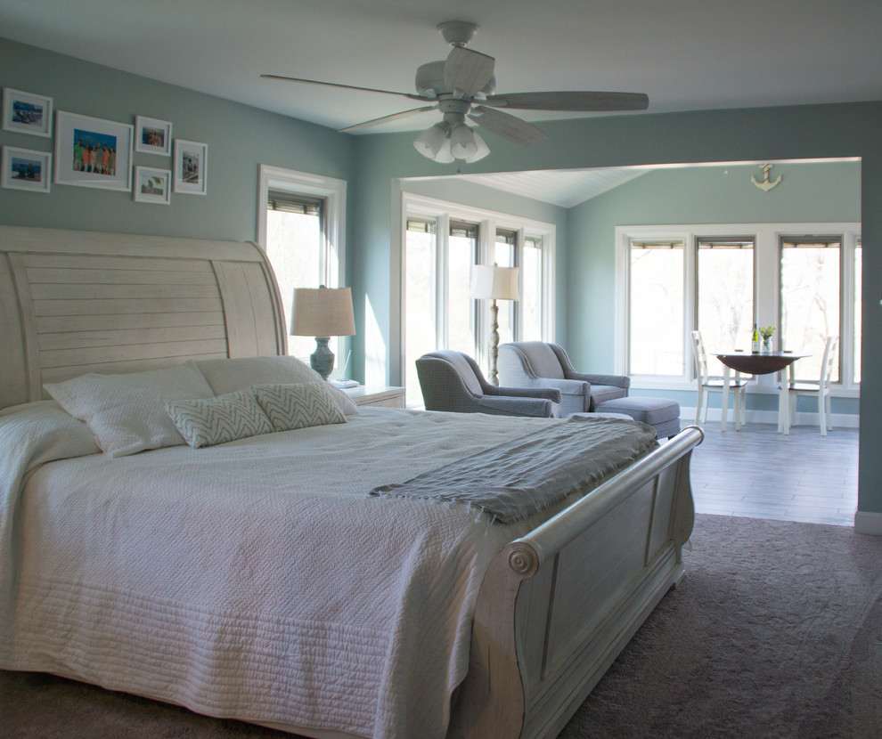 This is an example of a large beach style master bedroom in Other with green walls, porcelain floors, no fireplace and grey floor.