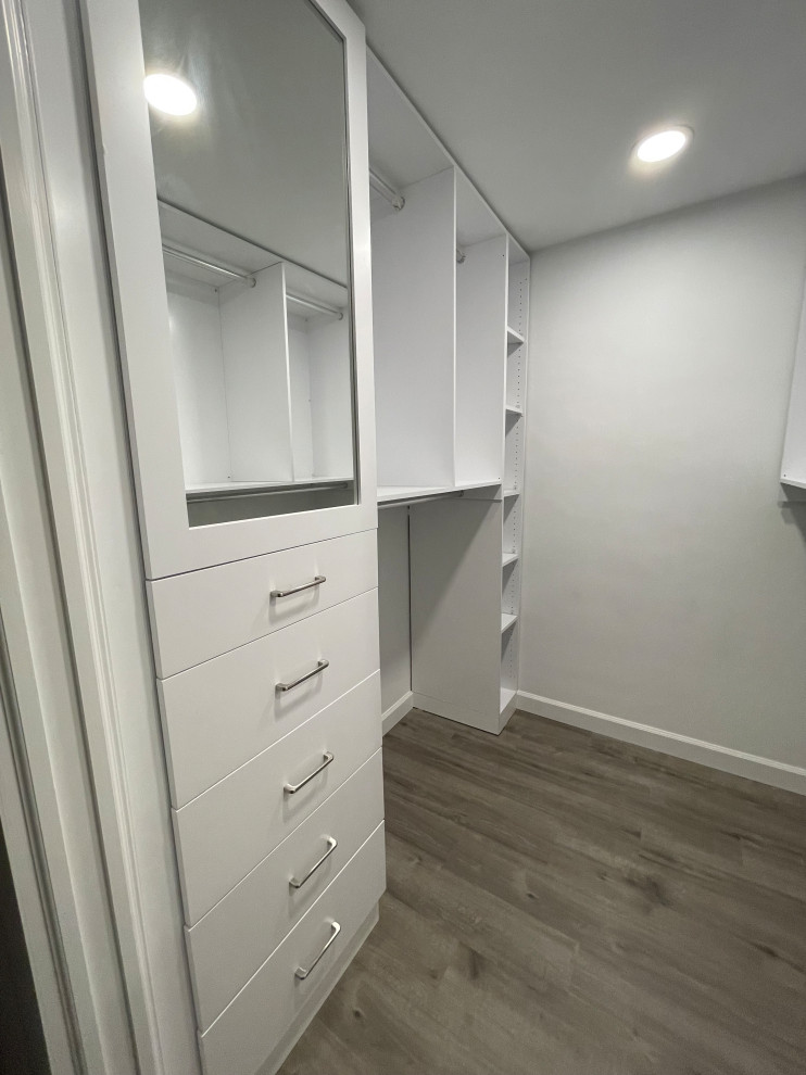 Walk-in closet - small contemporary gender-neutral medium tone wood floor and brown floor walk-in closet idea in Detroit with flat-panel cabinets and white cabinets