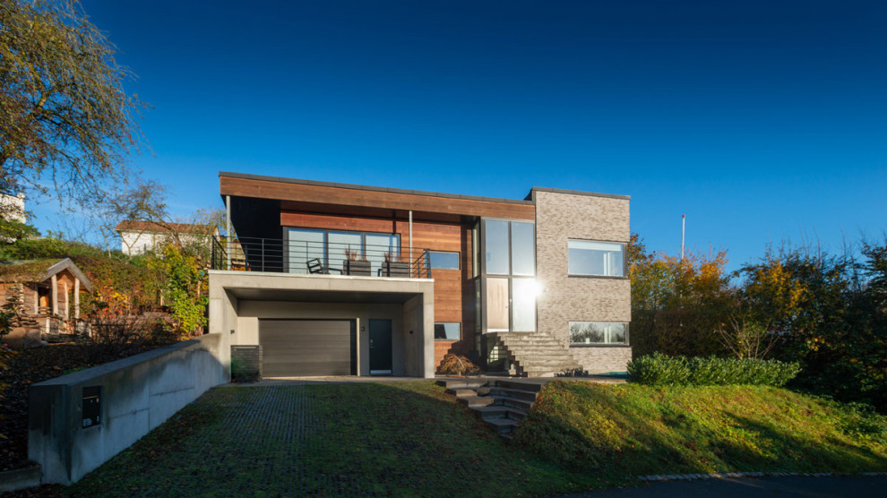 Exempel på ett mellanstort minimalistiskt grått hus, med två våningar, blandad fasad, platt tak och levande tak