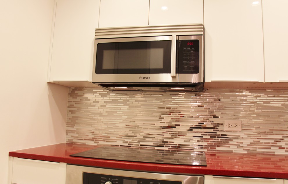 Photo of a contemporary eat-in kitchen in Miami with glass tile splashback.