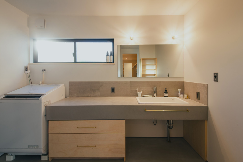Пример оригинального дизайна: туалет среднего размера: освещение в стиле модернизм с белыми фасадами, белыми стенами, бетонным полом, серым полом, серой столешницей, встроенной тумбой, потолком с обоями и обоями на стенах
