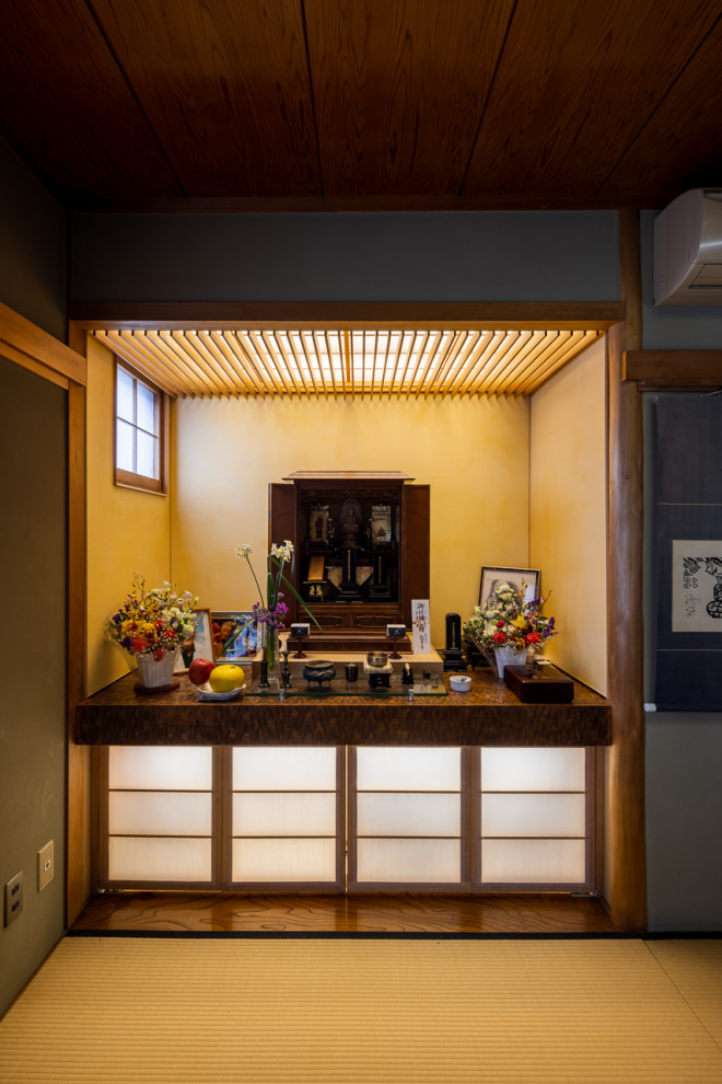 Modelo de despacho blanco de estilo zen pequeño sin chimenea con tatami, suelo verde, papel pintado, paredes amarillas y casetón