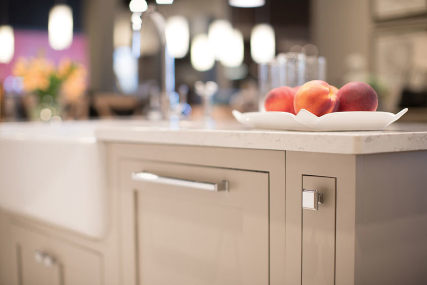 Example of a large transitional l-shaped open concept kitchen design in Orange County with shaker cabinets, quartz countertops, stainless steel appliances, an island, a farmhouse sink, beige cabinets and beige backsplash