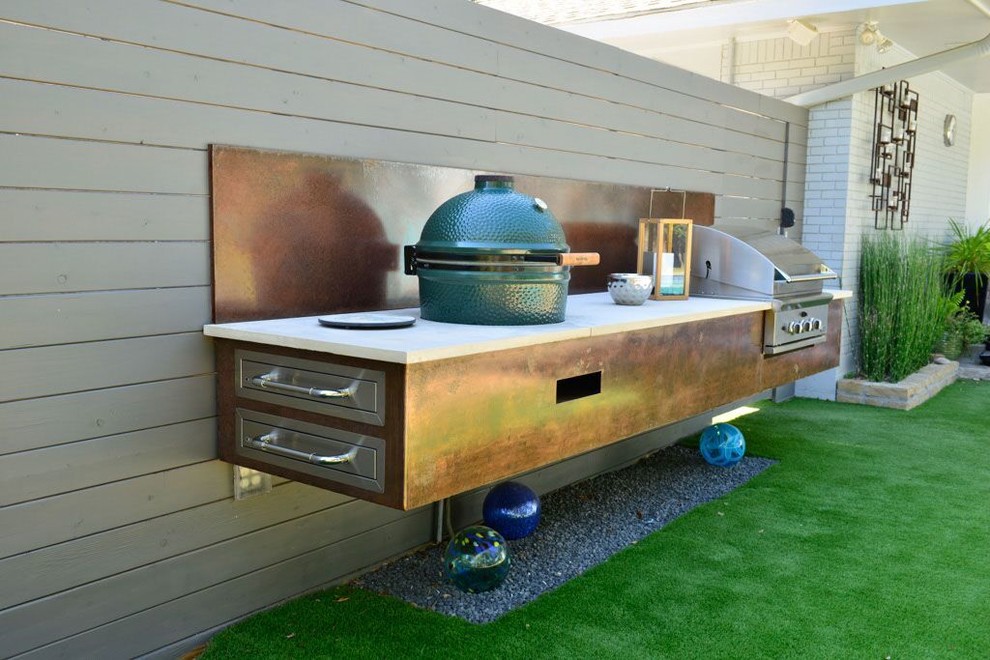 This is an example of a large contemporary backyard patio in Dallas with an outdoor kitchen, gravel and a pergola.