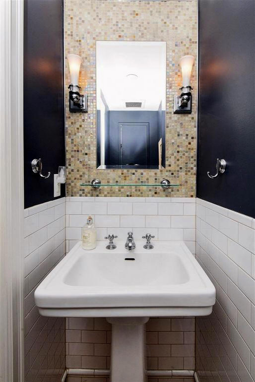 Photo of a small transitional powder room in New York with multi-coloured tile, glass tile, multi-coloured walls, cork floors, a pedestal sink, brown floor, glass-front cabinets, dark wood cabinets, a two-piece toilet, onyx benchtops, white benchtops, a built-in vanity, wood and wallpaper.