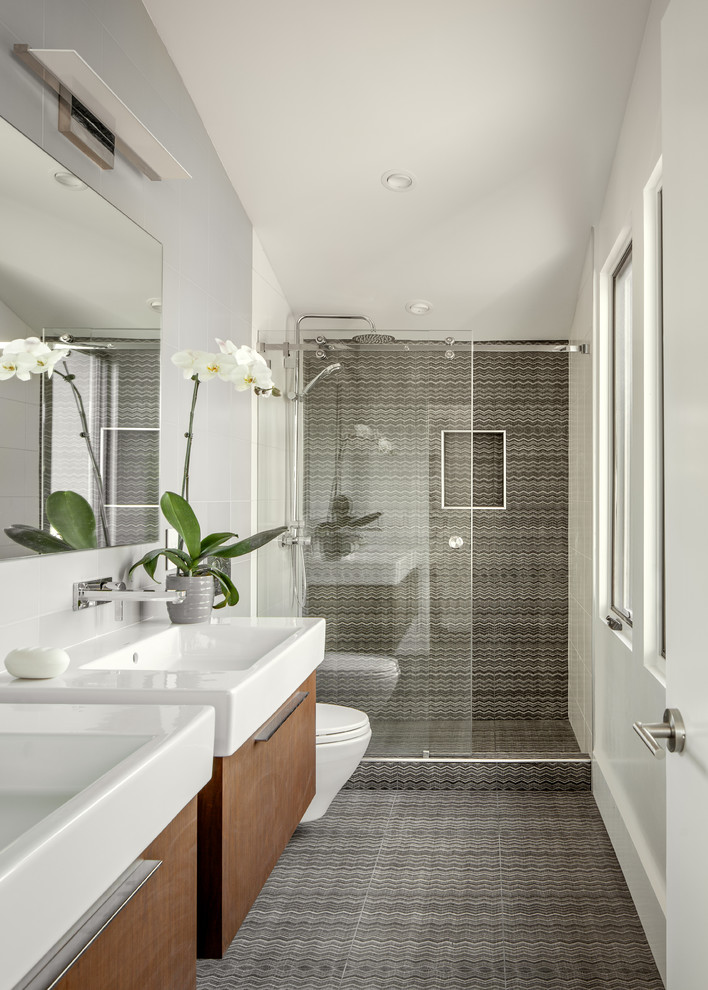 Modern master bathroom in San Francisco with flat-panel cabinets, brown cabinets, an alcove shower, a wall-mount toilet, brown tile, ceramic tile, white walls, vinyl floors, a vessel sink, solid surface benchtops, brown floor and a sliding shower screen.