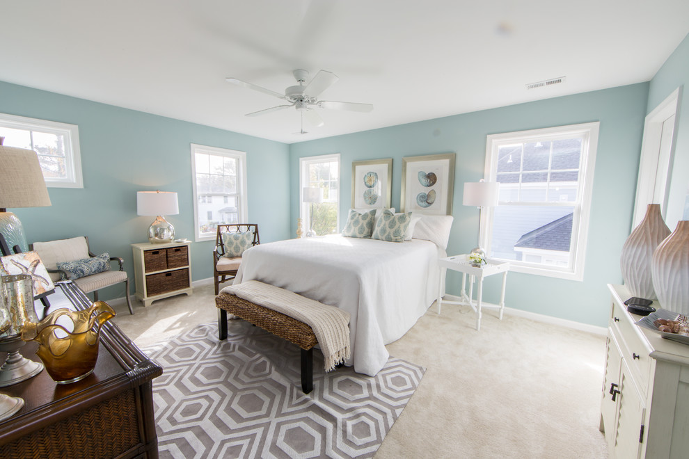 This is an example of a mid-sized beach style master bedroom in Other with blue walls and carpet.