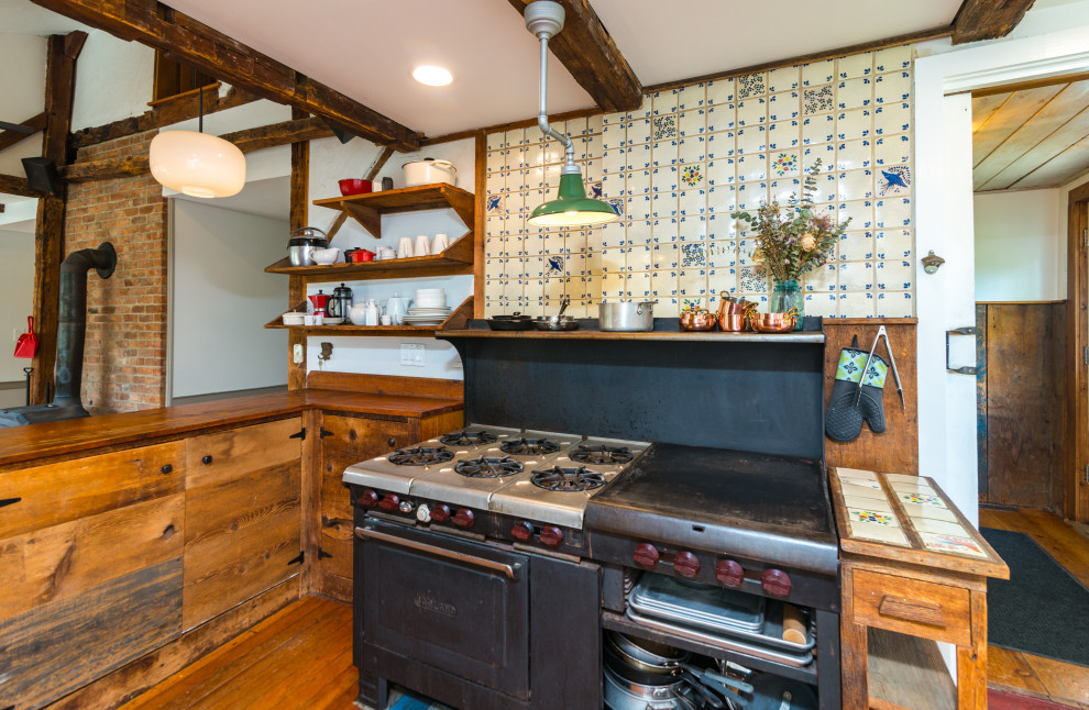 Lantlig inredning av ett mellanstort brun brunt kök och matrum, med en nedsänkt diskho, luckor med infälld panel, skåp i mellenmörkt trä, träbänkskiva, mellanmörkt trägolv och brunt golv