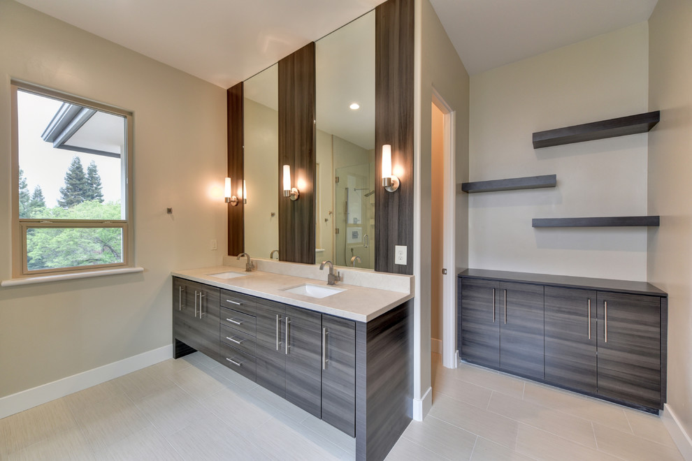 Inspiration for a large contemporary master bathroom in Sacramento with flat-panel cabinets, a freestanding tub, a drop-in sink, dark wood cabinets, an alcove shower, beige tile, travertine, beige walls, laminate floors, engineered quartz benchtops, beige floor, a hinged shower door and beige benchtops.
