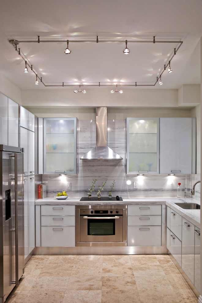 This is an example of a mid-sized contemporary u-shaped eat-in kitchen in Miami with an undermount sink, flat-panel cabinets, grey cabinets, stainless steel appliances, quartz benchtops, travertine floors and no island.