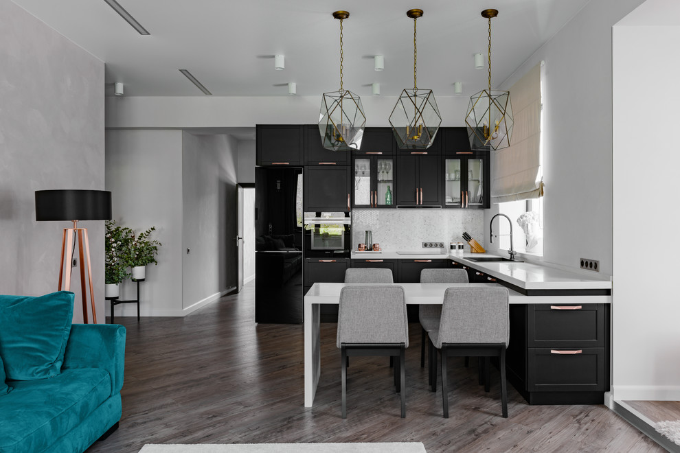 This is an example of a contemporary u-shaped kitchen in Other with a drop-in sink, shaker cabinets, black cabinets, grey splashback, black appliances, dark hardwood floors, a peninsula, brown floor and white benchtop.