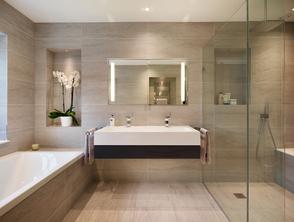 Photo of a large contemporary master bathroom in Surrey with flat-panel cabinets, dark wood cabinets, an alcove shower, gray tile, porcelain tile, grey walls, porcelain floors, a trough sink and a drop-in tub.