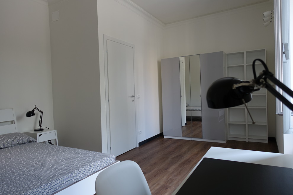 Foto di una camera da letto minimal di medie dimensioni con pareti bianche e pavimento in laminato