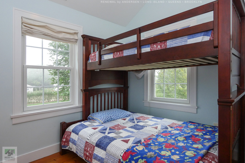 Cette image montre une chambre d'enfant de 4 à 10 ans de taille moyenne avec un mur bleu, un sol en bois brun et un plafond voûté.