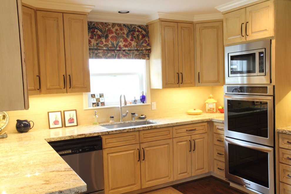 Example of a transitional kitchen design in Houston with raised-panel cabinets and light wood cabinets