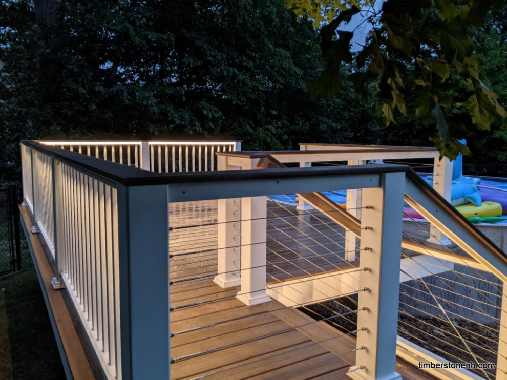 Mid-sized backyard and ground level deck in Manchester with cable railing.