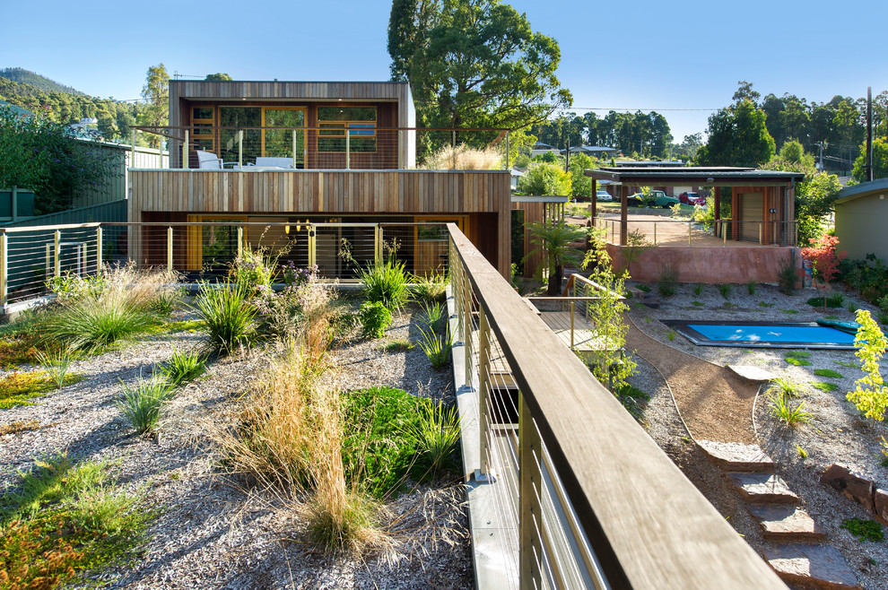 Contemporary three-storey brown exterior in Melbourne with wood siding and a flat roof.