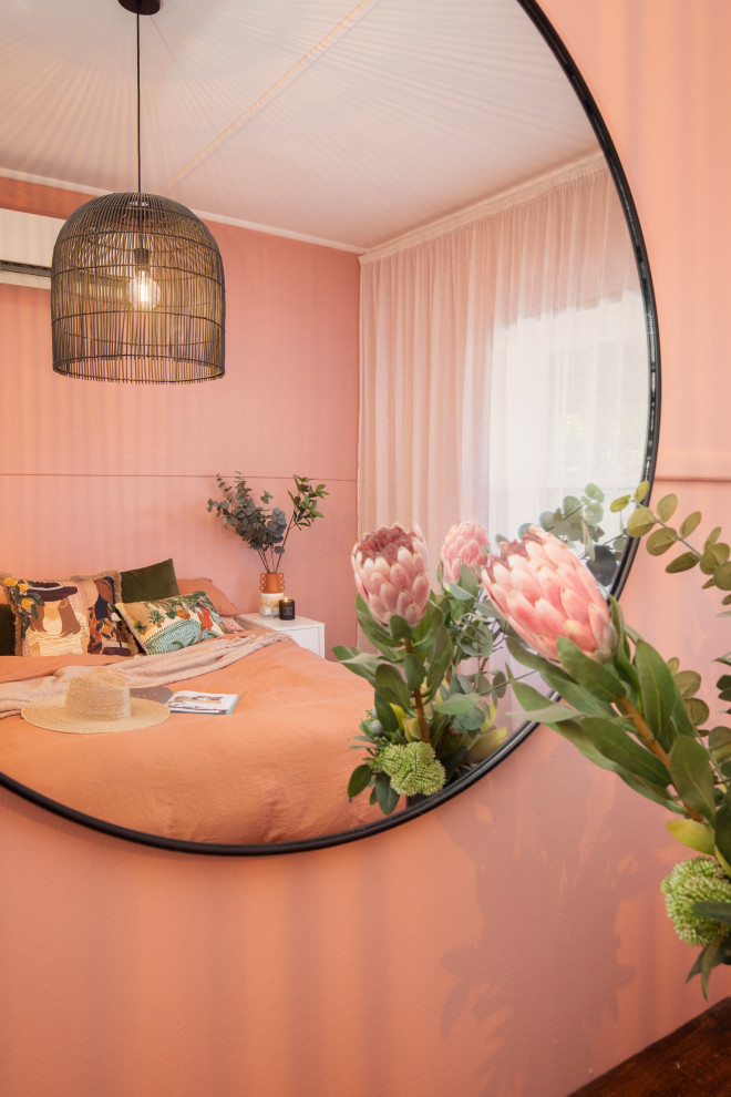 Ejemplo de dormitorio principal mediterráneo de tamaño medio con paredes rosas, suelo de madera oscura y suelo marrón