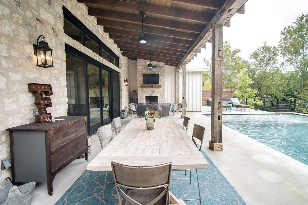 Inspiration for a mid-sized country backyard patio in Austin with concrete slab and a roof extension.