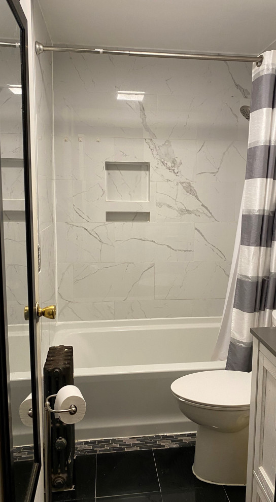 This is an example of a small transitional master bathroom in New York with recessed-panel cabinets, white cabinets, an alcove tub, a shower/bathtub combo, a two-piece toilet, multi-coloured tile, porcelain tile, multi-coloured walls, marble floors, an undermount sink, engineered quartz benchtops, black floor, a shower curtain, grey benchtops, a niche, a single vanity and a freestanding vanity.