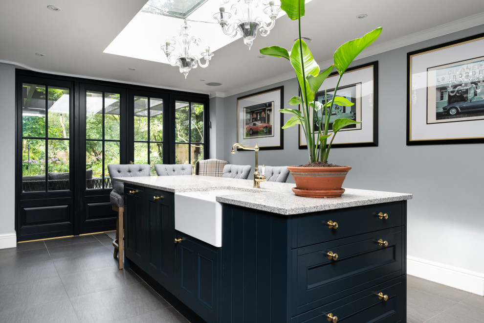 Klassische Wohnküche mit blauen Schränken, Granit-Arbeitsplatte, Küchenrückwand in Weiß, Rückwand aus Granit, Kücheninsel, grauem Boden und weißer Arbeitsplatte in London