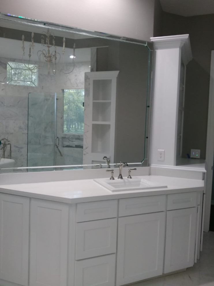 Inredning av ett mellanstort vit vitt en-suite badrum, med skåp i shakerstil, vita skåp, en hörndusch, en toalettstol med hel cisternkåpa, vit kakel, cementkakel, vita väggar, klinkergolv i keramik, ett konsol handfat, marmorbänkskiva, grått golv och med dusch som är öppen