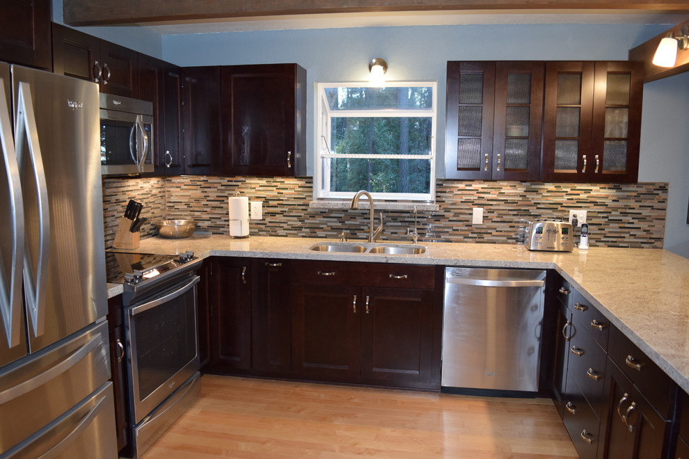 Inspiration for a mid-sized rustic u-shaped light wood floor eat-in kitchen remodel with an undermount sink, recessed-panel cabinets, dark wood cabinets, granite countertops, multicolored backsplash, stainless steel appliances and a peninsula